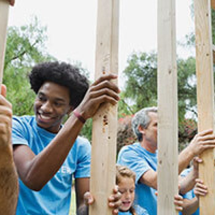 Group of volunteers holding wooden frame at park